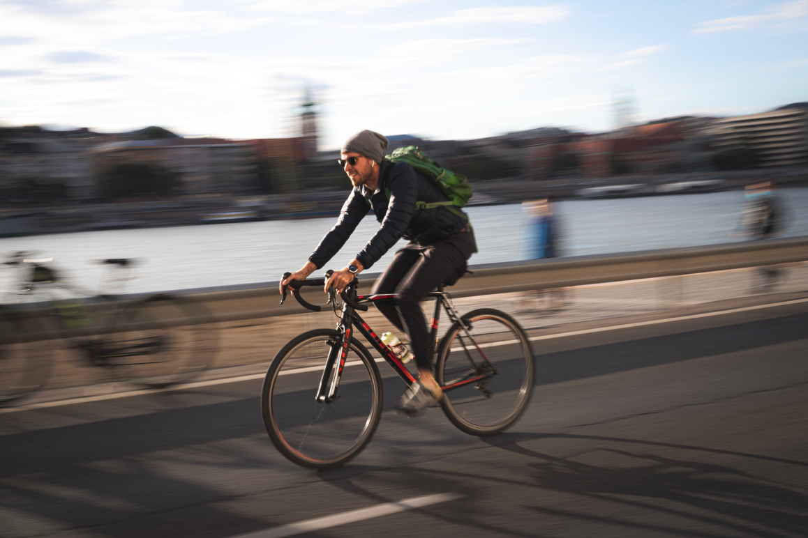 Ein Mann auf einem Rennrad, der gerade auf der Straße fährt.