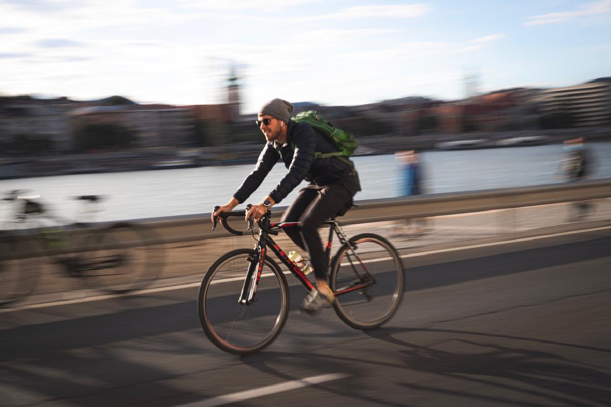 Ein Mann auf einem Rennrad, der gerade auf der Straße fährt.