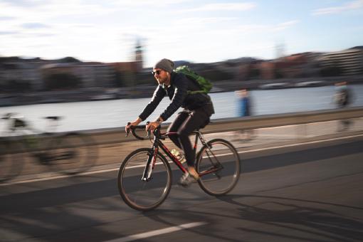 Ein Mann auf einem Rennrad, der gerade auf der Straße fährt.