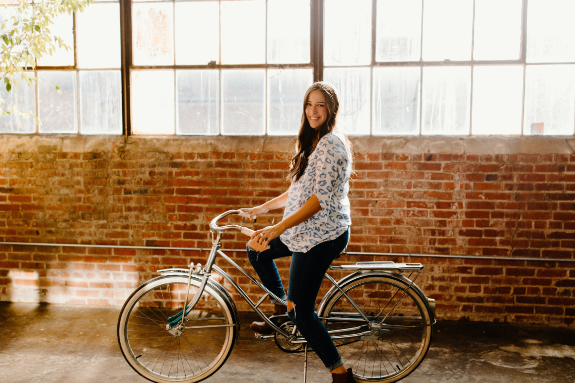 Eine Frau, die auf einem Fahrrad sitzt. Das Fahrrad hat sie über eine Fahrradversicherung über die Versicherungs-App Sophia versichert.