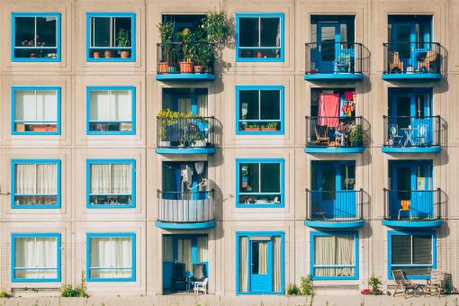 Apartmentgebäude mit blauen Fenstern und Balkonen.