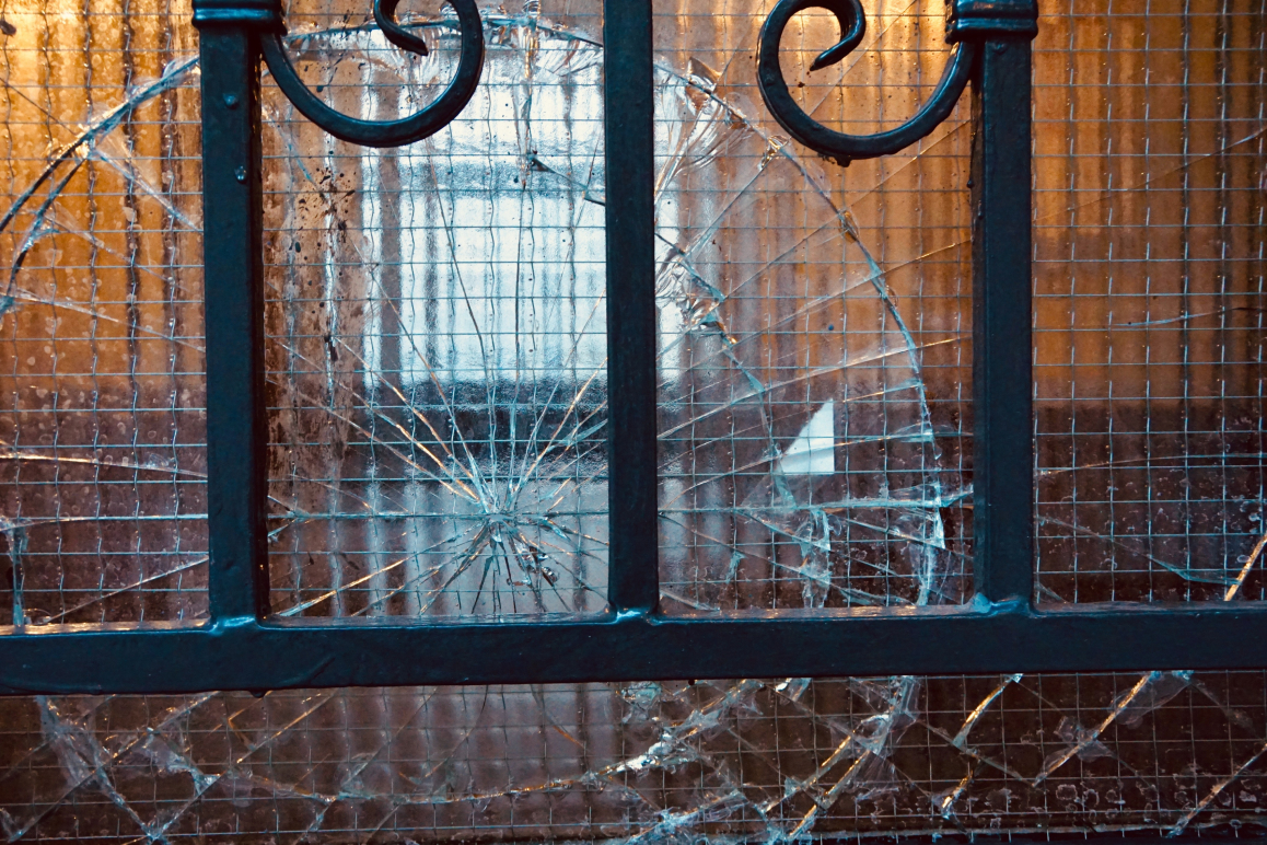 Eine zerbrochene Glasscheibe in einer Tür. Die Haushaltsversicherung deckt diesen Glasbruch.