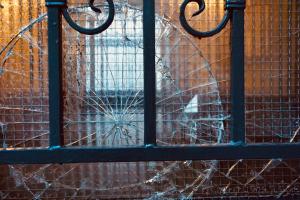 Eine zerbrochene Glasscheibe in einer Tür. Die Haushaltsversicherung deckt diesen Glasbruch.