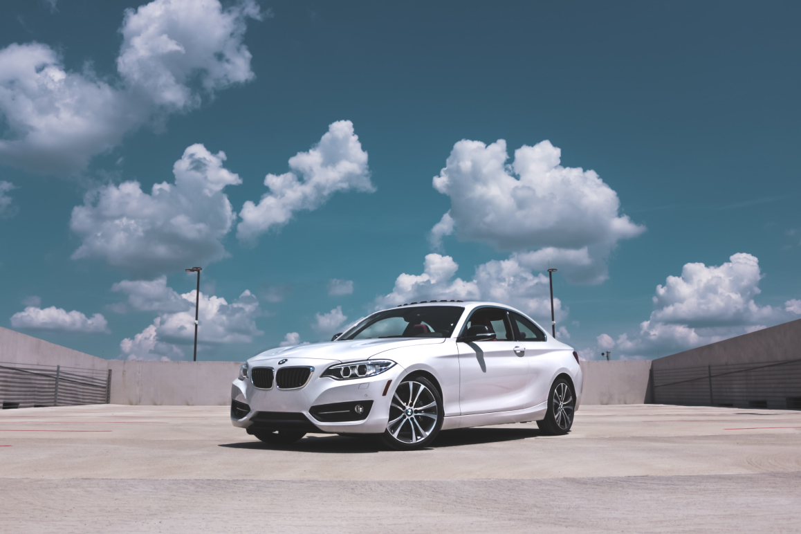 Ein weißer BMW. Im Hintergrund befindet sich blauer Himmel mit Wolken.