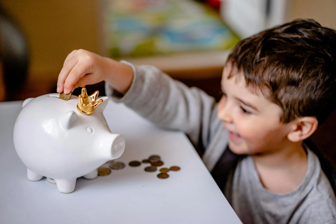 Ein kleiner Junge freut sich, weil durch die Spartipps bei der privaten Krankenversicherung Geld eingespart wurde – so kann er mehr in sein Sparschwein stecken.