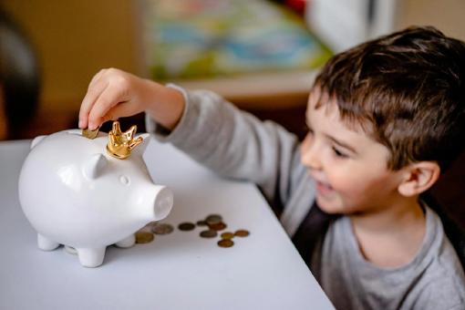 Ein kleiner Junge freut sich, weil durch die Spartipps bei der privaten Krankenversicherung Geld eingespart wurde – so kann er mehr in sein Sparschwein stecken.