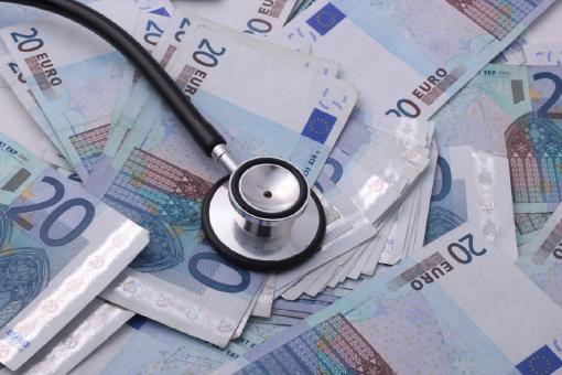 Viele Zwanzig-Euro-Scheine und ein Stethoskop, die auf die Kosten für eine private Krankenversicherung hinweisen.