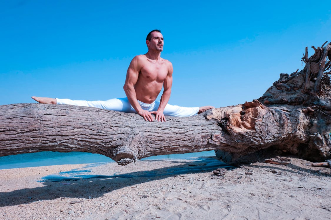 Ein Mann, der Yoga macht und über eine Merkur Zusatzversicherung abgesichert ist.