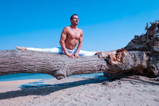 Ein Mann, der Yoga macht und über eine Merkur Zusatzversicherung abgesichert ist.