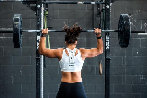 Eine Frau im Fitnessstudio beim Gewichtheben.