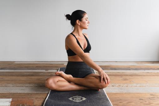 Eine Frau, die gerade Yoga macht und eine private Krankenversicherung in Österreich abgeschlossen hat.